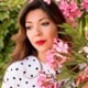 Profile pic of a brunette woman near flowers